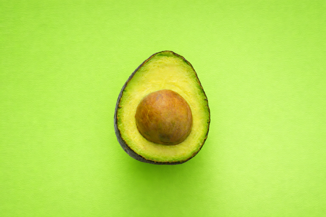An avocado on a green background added with AI
