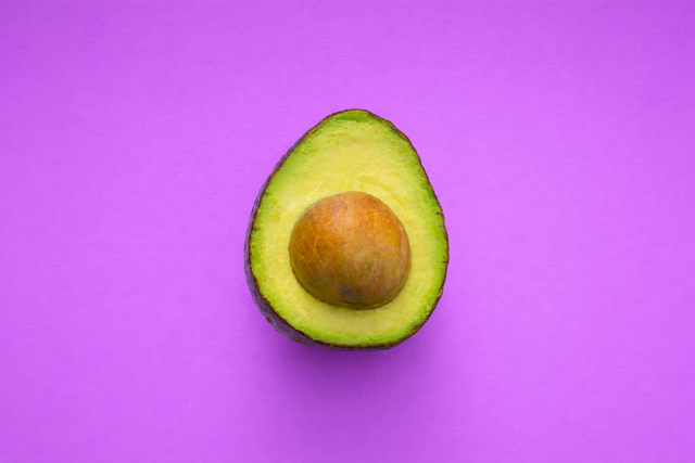 An avocado on a purple background added with AI