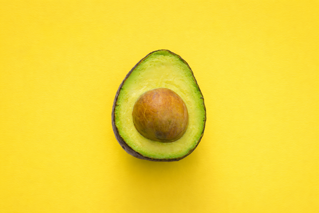 An avocado on a yellow background added with AI
