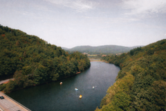 Large body of water with boats on it, surrounded by trees on both sides — sample image to upscale