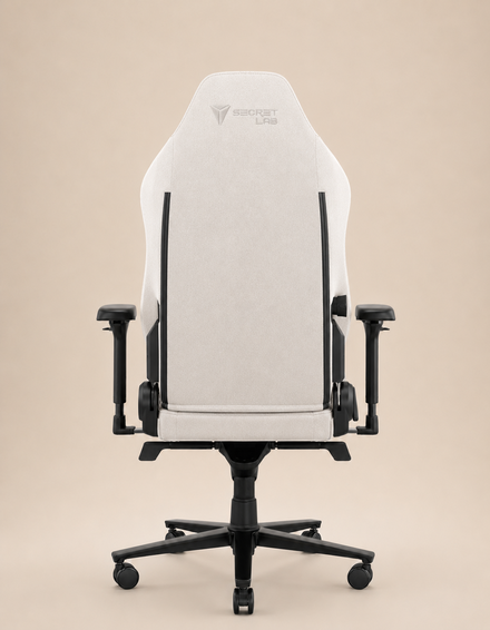 A rear view of a white gaming chair with a high backrest, armrests, and a beige background.