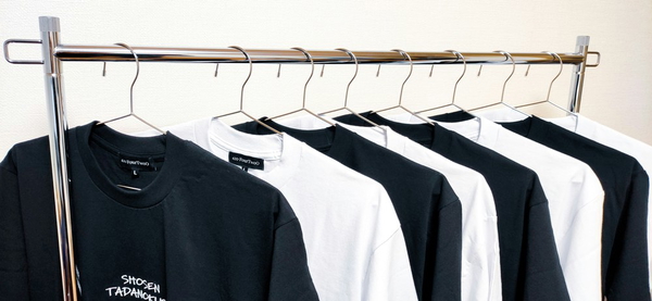 A rail of black and white t-shirts on wire hangers