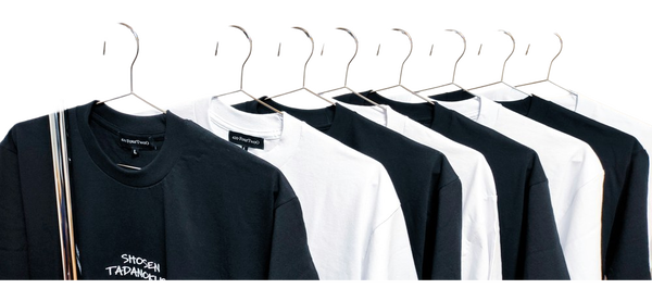 A rail of black and white t-shirts on wire hangers — background removed by iLoveIMG