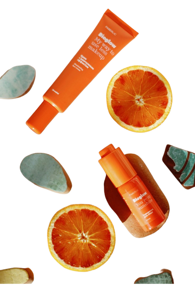 Orange skincare tubes scattered with blood orange slices — background removed by iLoveIMG