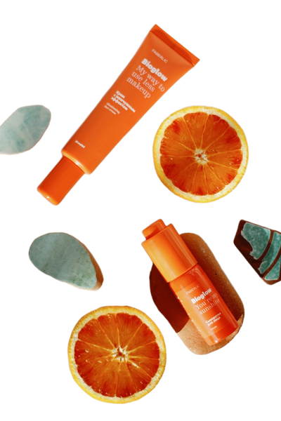 Orange skincare tubes scattered with blood orange slices — background removed by Photoroom