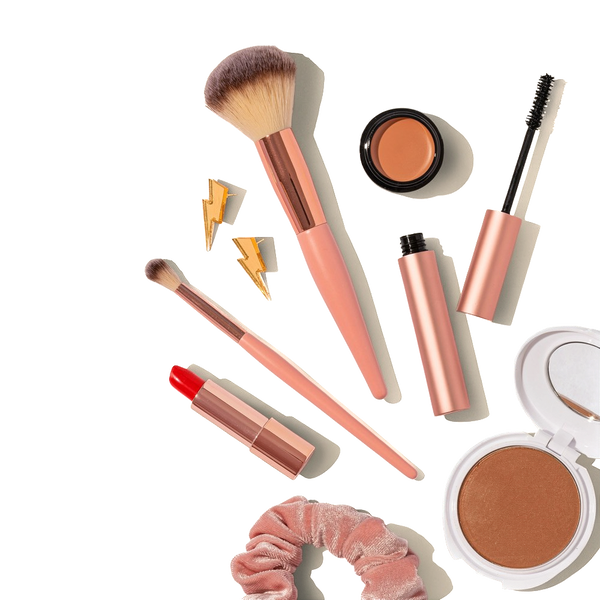 Make-up brushes, lipsticks and compacts on a beige background — background removed by Remove.bg