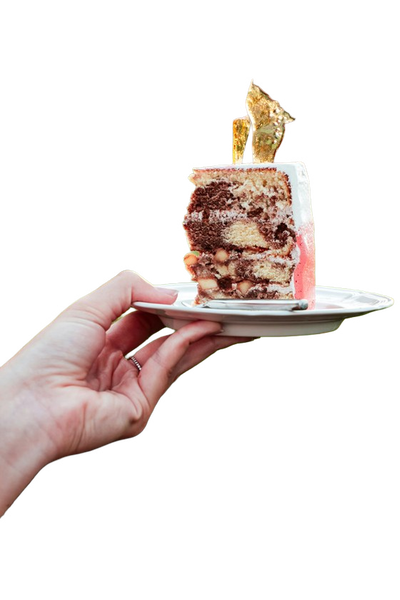 A hand holding a small cake on a plate — background removed by iLoveIMG