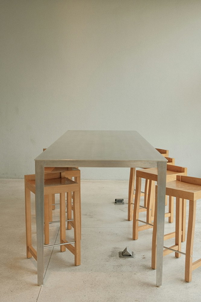 A pale dining table with stools tucked underneath