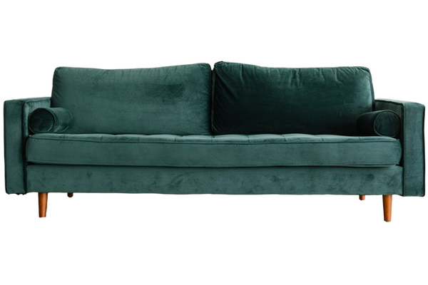 A green velvet sofa on a wooden floor — background removed by iLoveIMG