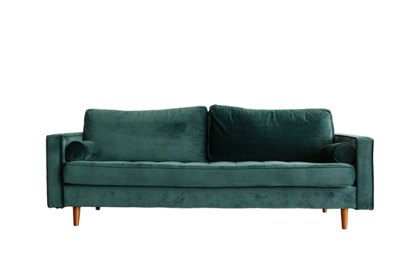 A green velvet sofa on a wooden floor — background removed by Photoroom