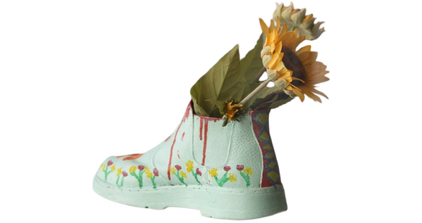 Sunflowers arranged in a pale green boot-shaped vase — background removed by iLoveIMG