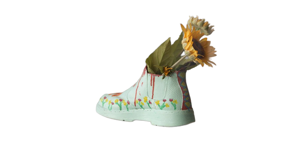 Sunflowers arranged in a pale green boot-shaped vase — background removed by Erase.bg