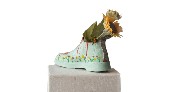 Sunflowers arranged in a pale green boot-shaped vase — background removed by Photoroom