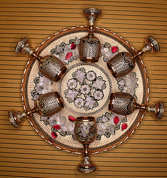A brass wall ornament with candle holders around its rim
