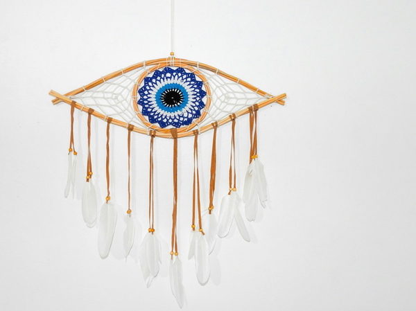 An evil eye wall hanging with feather tassels