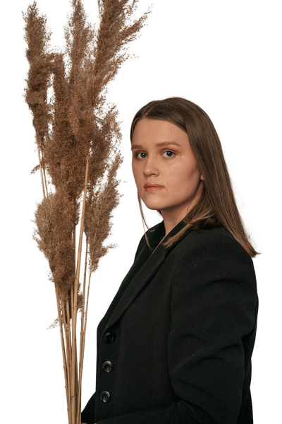 A woman in a dark blazer in front of dried pampas grass — background removed by iLoveIMG