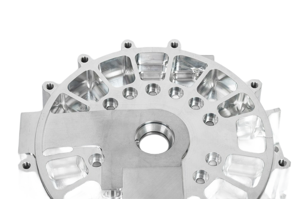 A machined aluminium housing with bolt holes — background removed by Erase.bg