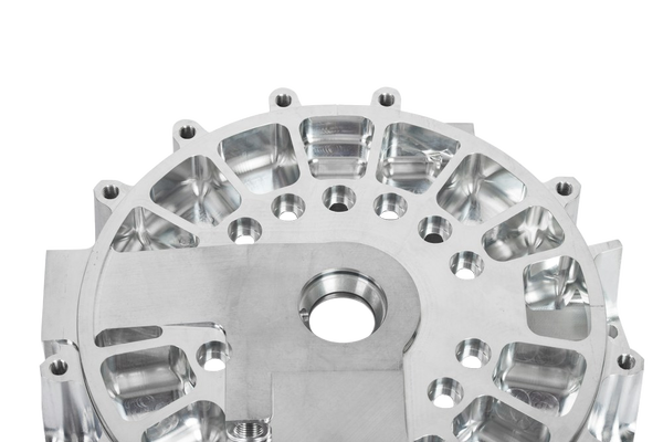 A machined aluminium housing with bolt holes — background removed by Remove.bg