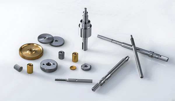 Shafts, gears and washers laid out on a blue surface