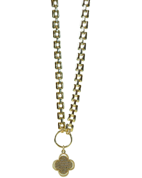 A gold chain necklace with a pendant, lying on a green leaf — background removed by iLoveIMG