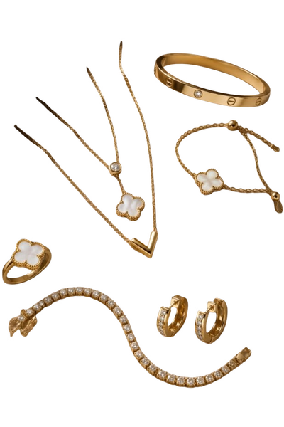 A flat-lay of gold necklaces, bangles, a ring and hoop earrings on beige satin — background removed by iLoveIMG