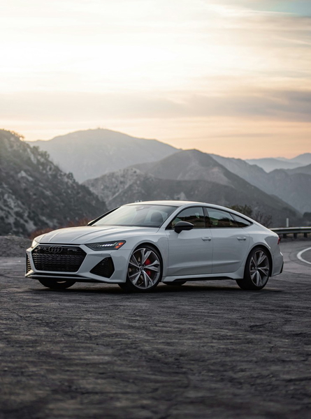 A silver sports coupe photographed against mountains