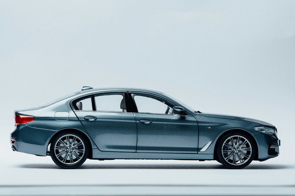 A dark blue saloon photographed in profile in a studio