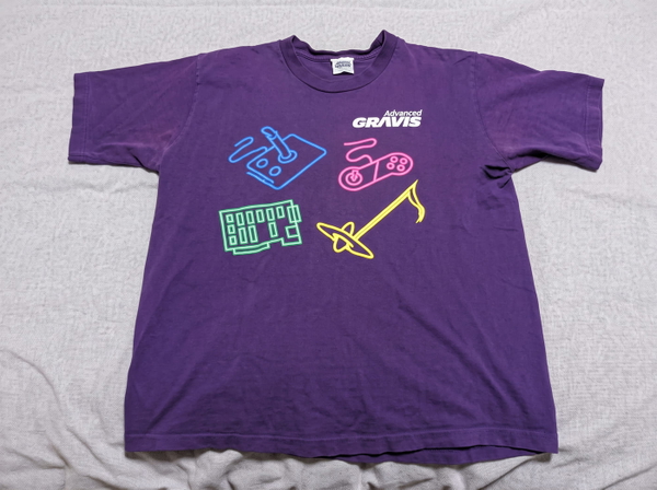 Purple T-shirt with a neon musical-instrument print, laid flat on a sheet — upscaled by GoStudio Advanced