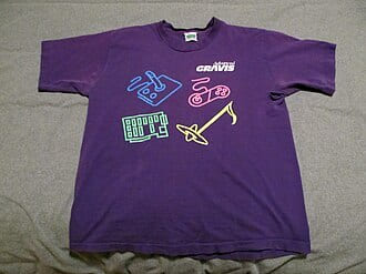 Purple T-shirt with a neon musical-instrument print, laid flat on a sheet