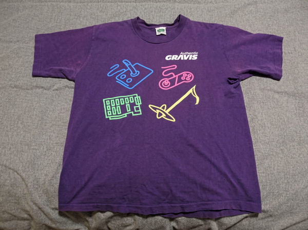 Purple T-shirt with a neon musical-instrument print, laid flat on a sheet — upscaled by Nano Banana 2