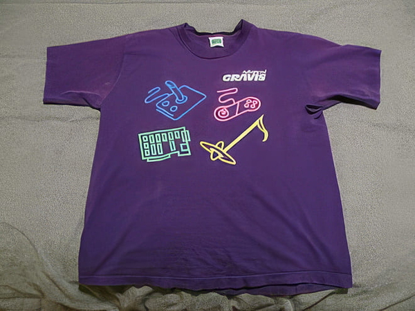 Purple T-shirt with a neon musical-instrument print, laid flat on a sheet — upscaled by GoStudio Pro