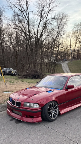 Red coupé parked on a driveway in front of bare winter trees — upscaled by Nano Banana 2