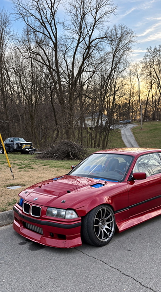 Red coupé parked on a driveway in front of bare winter trees — upscaled by GPT Image 2.5