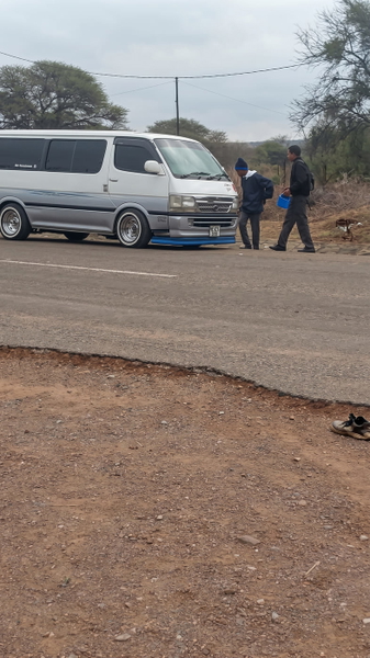 White van on a dirt road with two people standing beside it — upscaled by Nano Banana 2