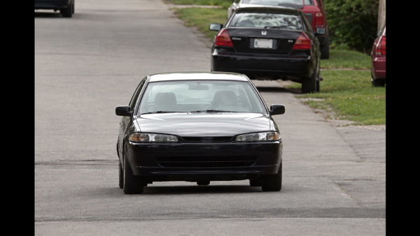 White hatchback on a suburban road, from a 1280×720 video still — upscaled by GPT Image 2.5