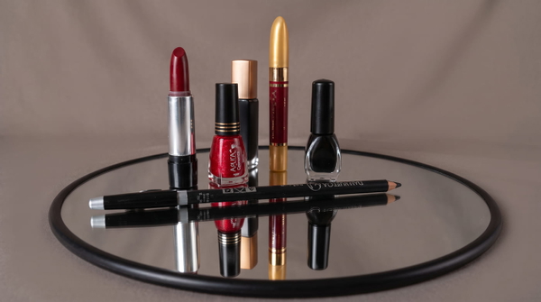 Lipsticks and nail polish arranged on a round mirrored tray — upscaled by GoStudio Advanced