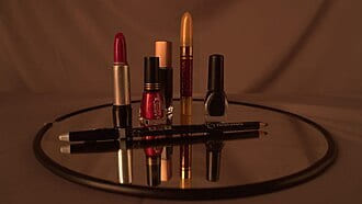 Lipsticks and nail polish arranged on a round mirrored tray