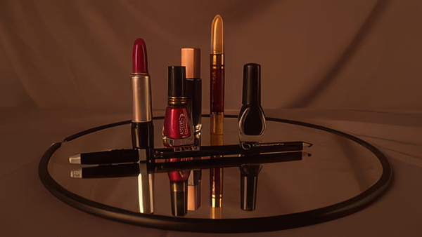 Lipsticks and nail polish arranged on a round mirrored tray — upscaled by GoStudio Pro