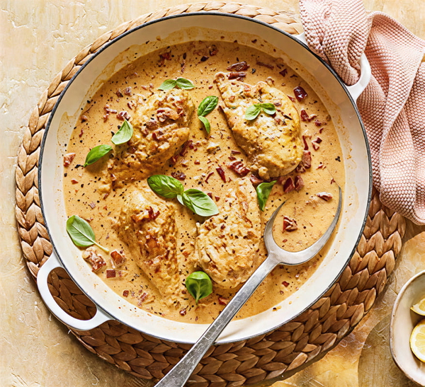 Chicken in a cream sauce in a white pan, garnished with basil, on a woven mat — upscaled by GoStudio Pro
