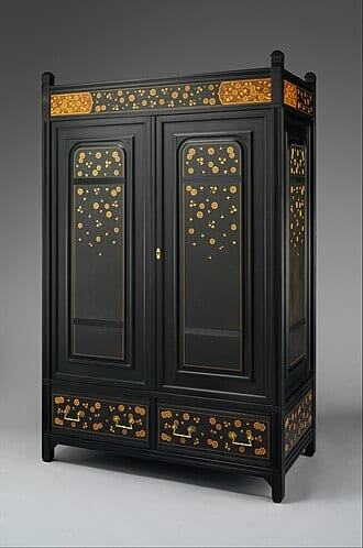 Black lacquered cabinet with gilt floral decoration on a grey studio backdrop