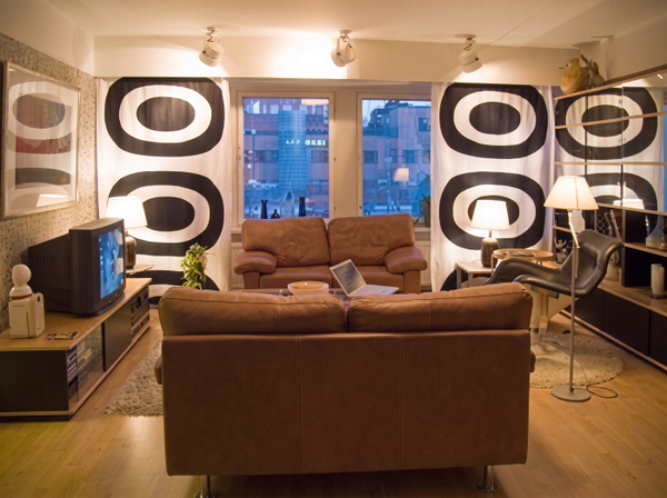 Living room with brown leather sofas and bold black-and-white patterned walls — upscaled by GoStudio Advanced