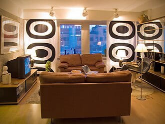 Living room with brown leather sofas and bold black-and-white patterned walls