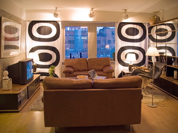 Living room with brown leather sofas and bold black-and-white patterned walls — upscaled by Nano Banana 2