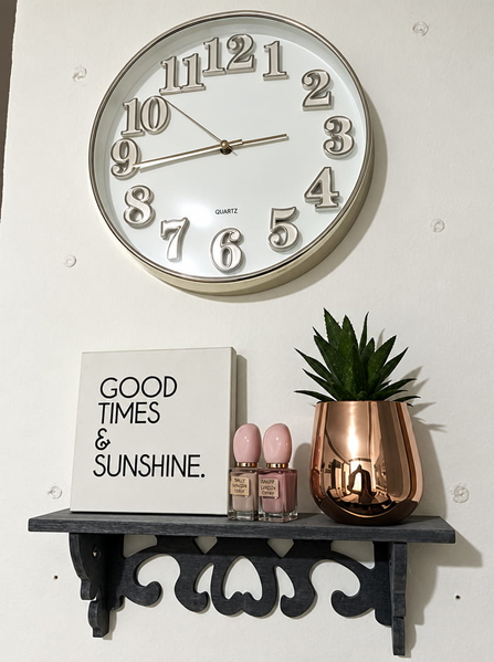 Wall clock above a shelf with a "Good times & sunshine" sign and a succulent — upscaled by GPT Image 2.5
