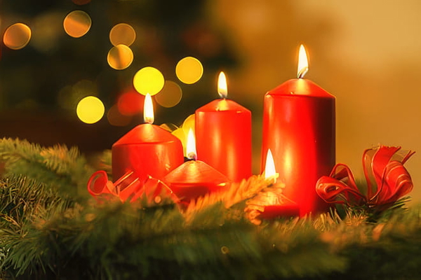 Red candles lit on a pine garland with bokeh lights behind — upscaled by GoStudio Pro
