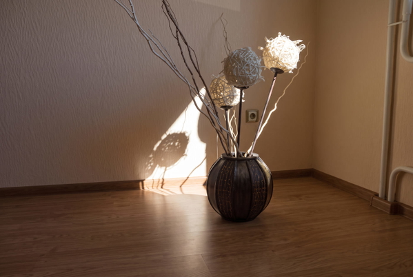 Vase of dried branches casting a shadow in a sunlit corner of a room — upscaled by GoStudio Advanced