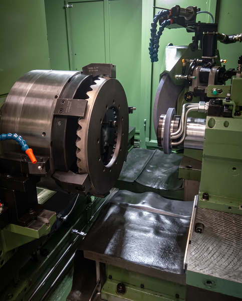 CNC lathe with a chuck and tooling, in a green machine enclosure — upscaled by GoStudio Advanced