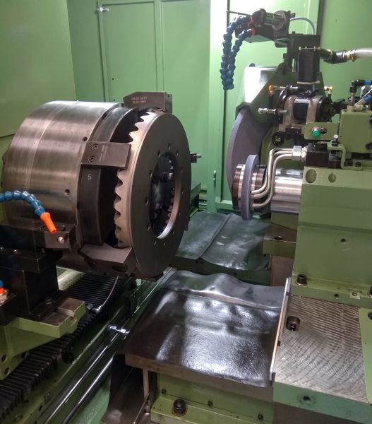 CNC lathe with a chuck and tooling, in a green machine enclosure — upscaled by Nano Banana 2