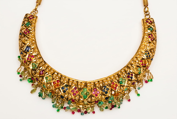 Gold collar necklace set with coloured stones on a pale background — upscaled by GoStudio Advanced