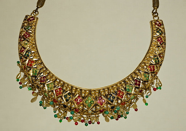 Gold collar necklace set with coloured stones on a pale background — upscaled by GPT Image 2.5